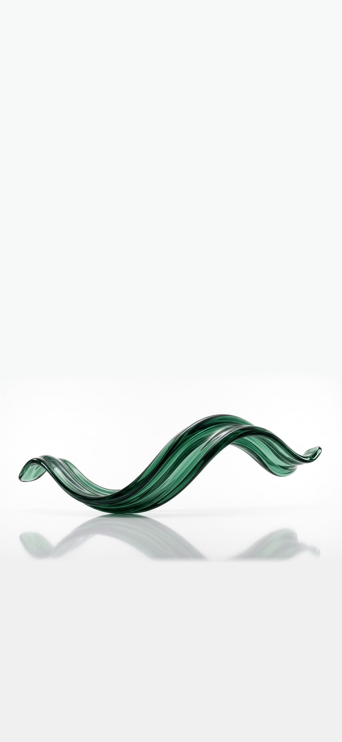 A green glass sculpture, curved like a wave, on a pale background